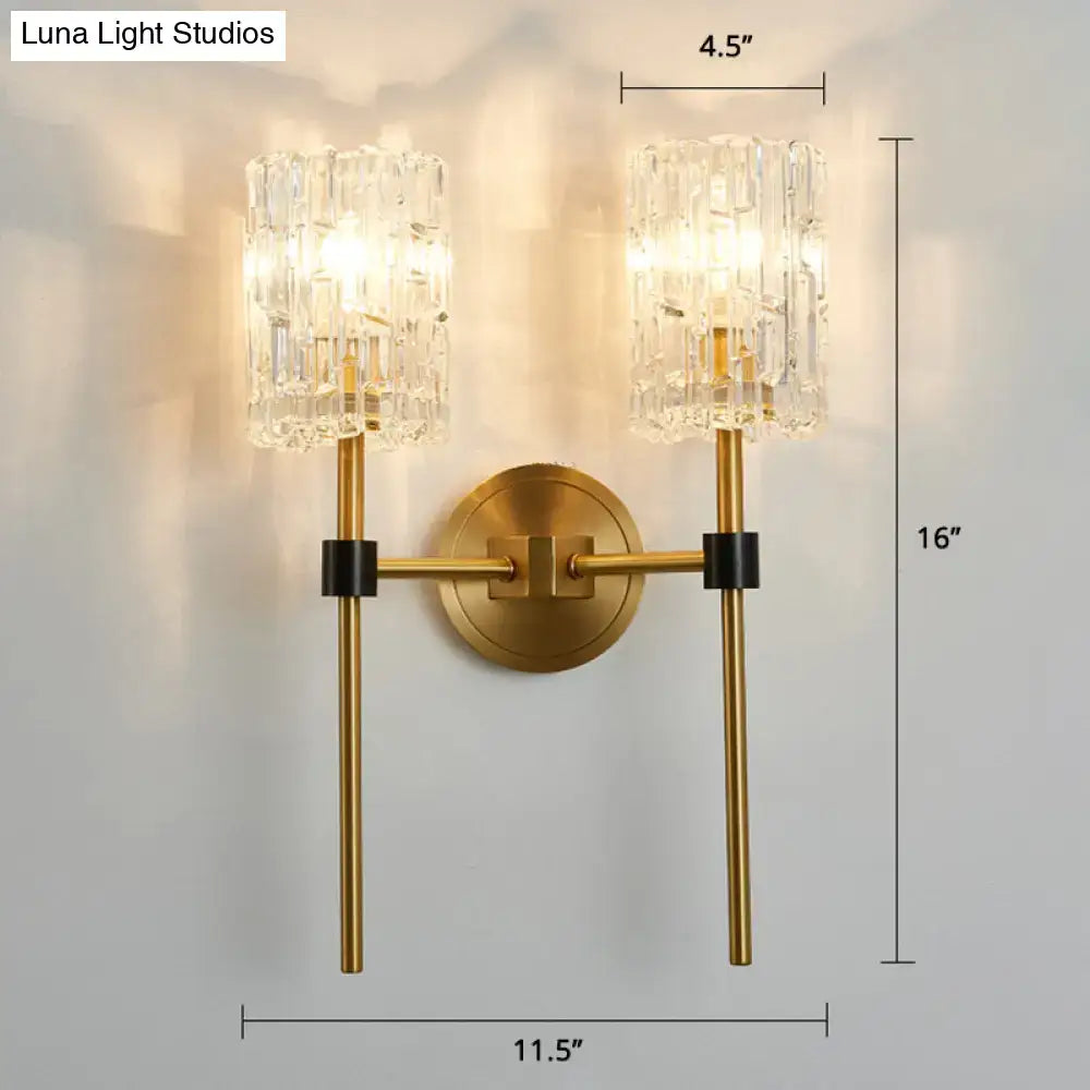 Modern gold and black wall sconce with gold finish, crystal cylindrical shades, and black accent bands as wall light