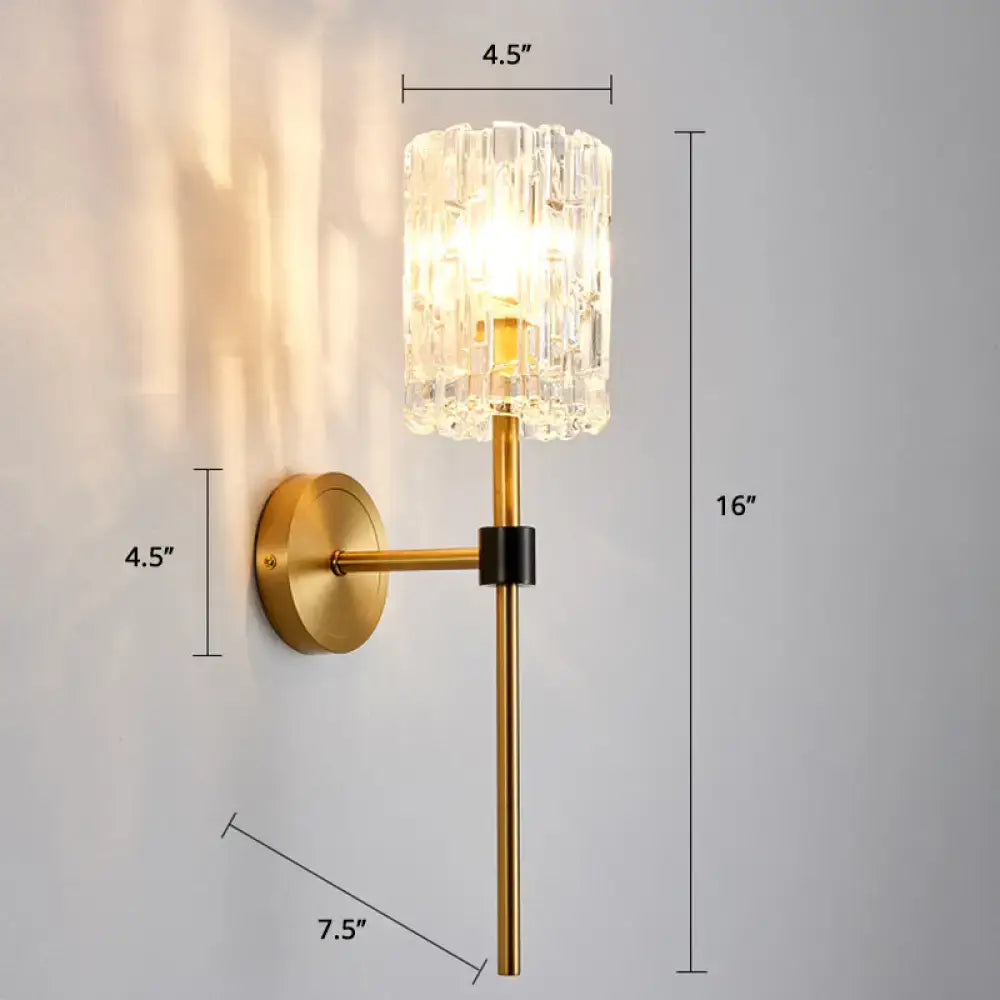 Modern gold and black wall sconce with a gold finish cylindrical crystal glass shade and black accent wall light for living room