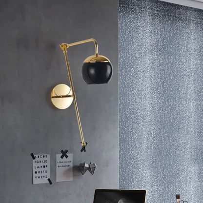 Modern gold wall sconce with adjustable arm and clear black glass spherical lampshade for bedroom lighting