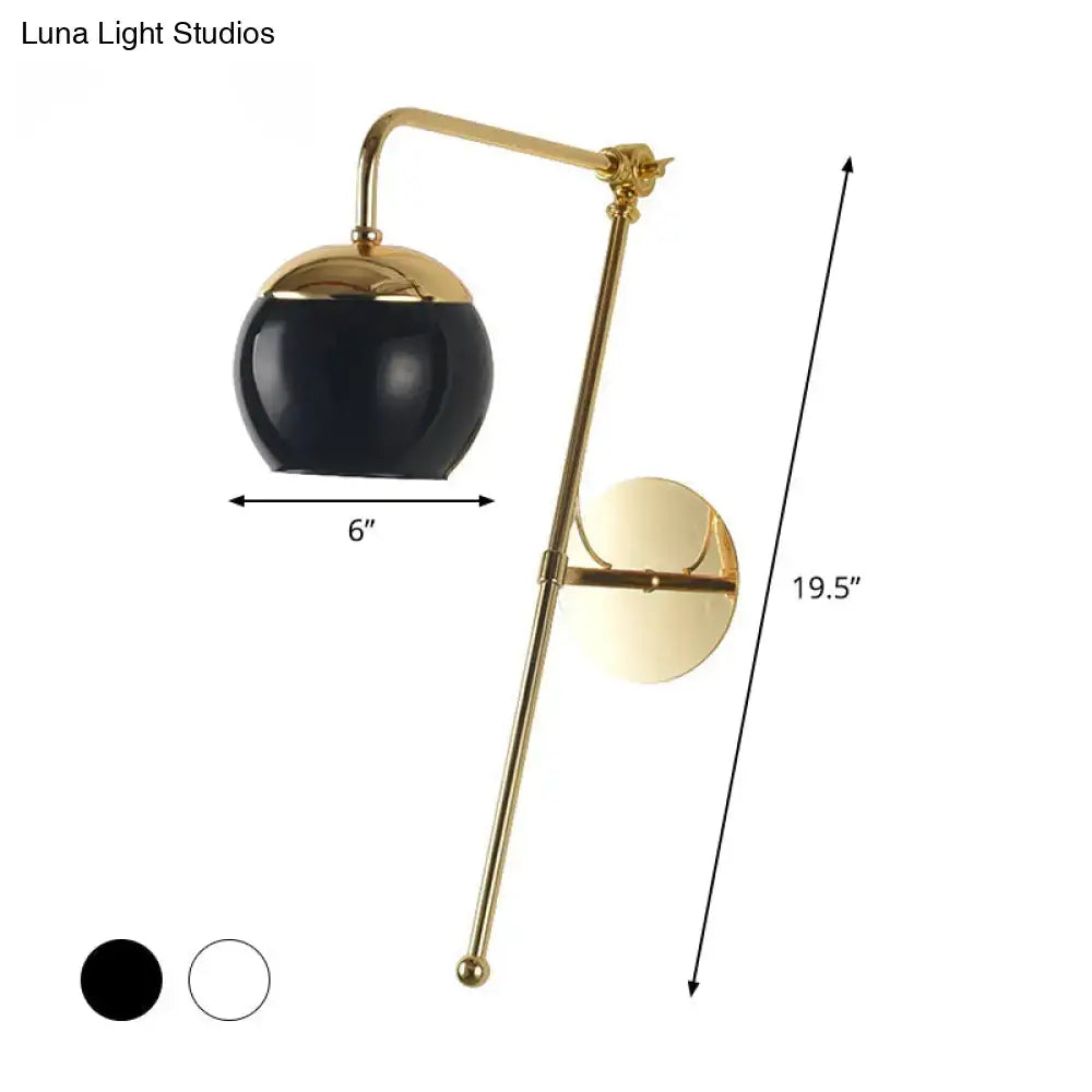 Modern gold wall sconce with a clear black glass spherical shade for bedroom lighting