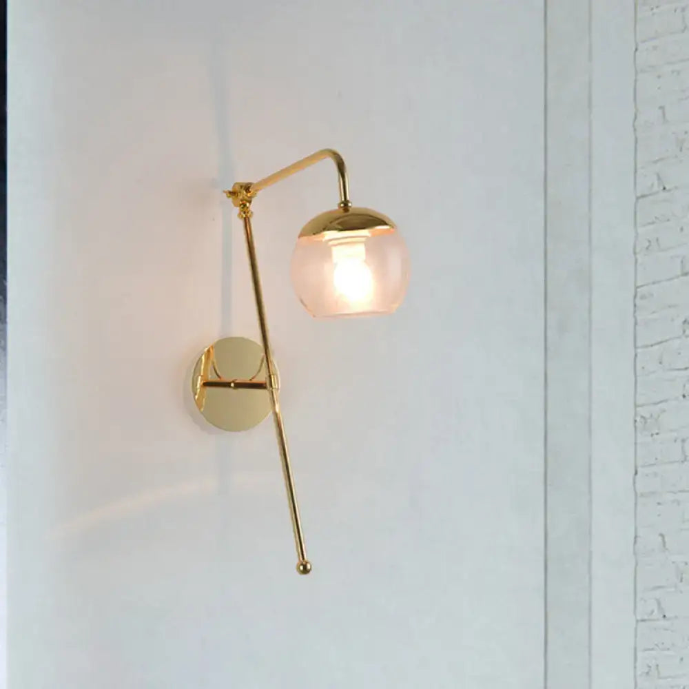 Modern gold wall sconce with spherical frosted glass shade and articulated arm featuring clear black glass accents