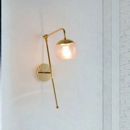 Modern gold wall sconce with spherical frosted glass shade and articulated arm featuring clear black glass accents