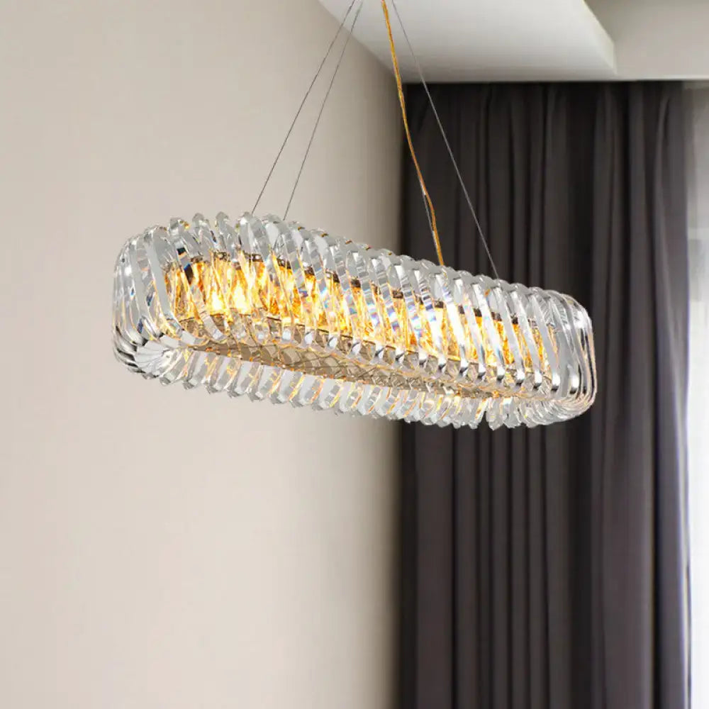 Modern gold and clear crystal oval pendant light with faceted crystal elements for dining room illumination