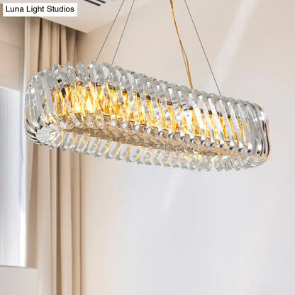 Modern gold pendant light with overlapping clear crystal prisms and warm led lights for dining room illumination