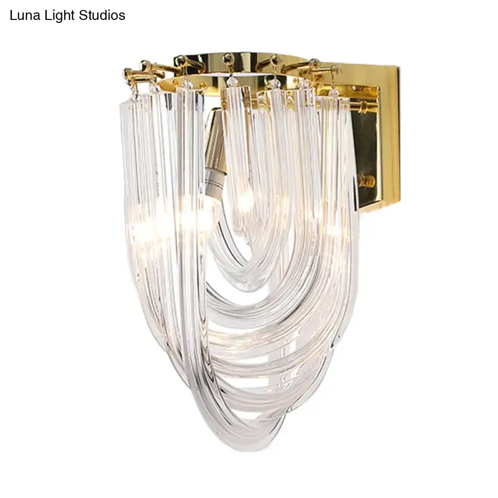 Elegant gold-finished living room wall sconce with cascading clear glass geometric tubes and a curved flowing design