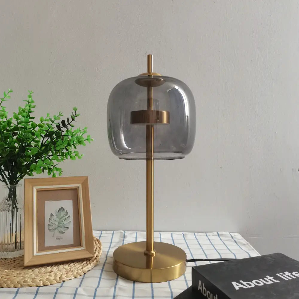 Modern gold and gray glass table lamp set featuring a brass finished table lamp with a rounded smoked glass shade