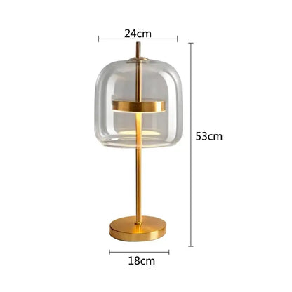 Modern gold and gray glass table lamp featuring a clear glass dome and gold-toned metal frame for bedroom use