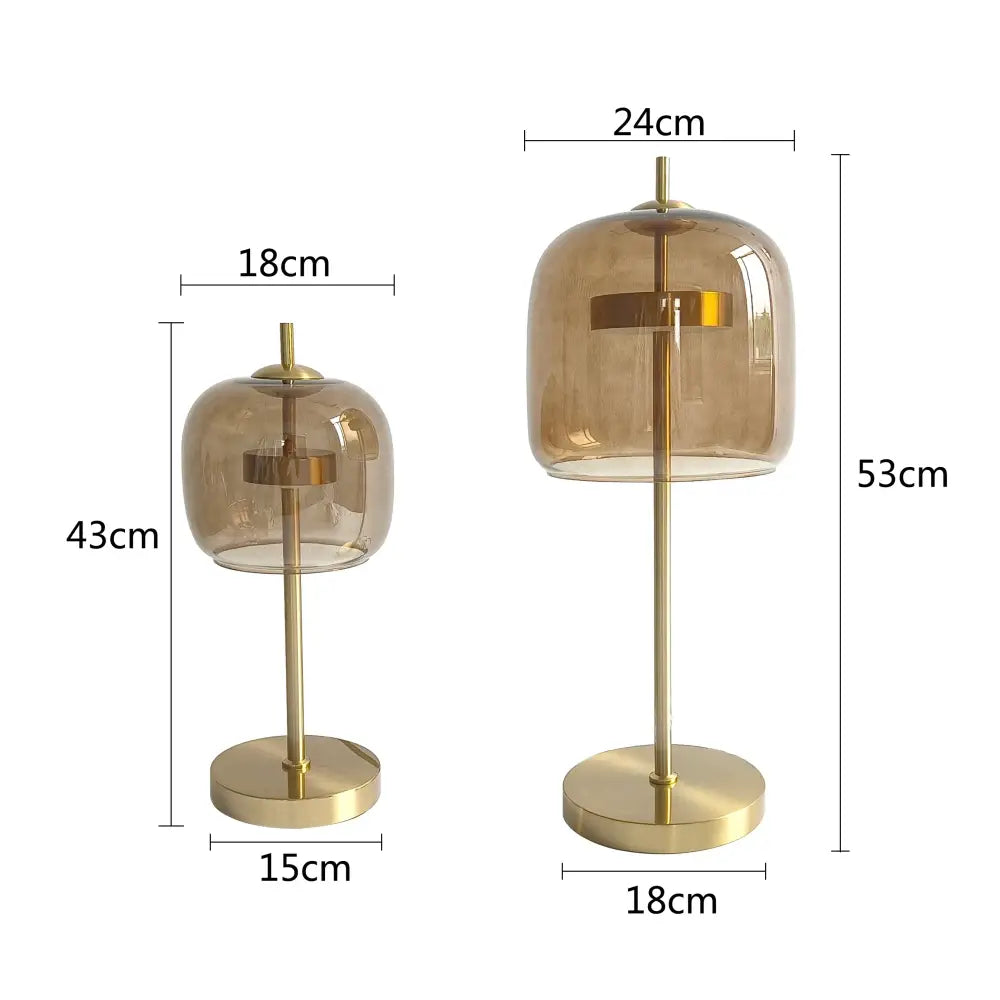 Two modern table lamps with amber glass shades and gold metal bases in a sleek glass table lamp set for bedroom