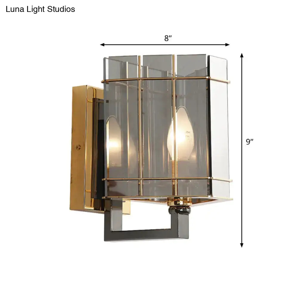 Modern gold wall sconce with smoke gray glass triangle enclosure and black metal base for bedroom lighting