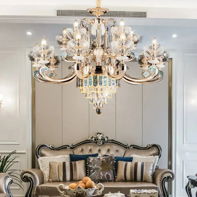 Modern gold and teal crystal candle chandelier with decorbites crystal accents hanging above a luxurious sofa