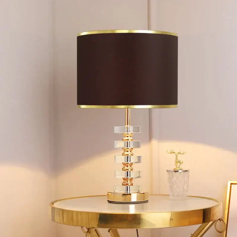 Modern gold and white decorbites crystal table lamp with black fabric shade and tiered clear crystal polished brass base