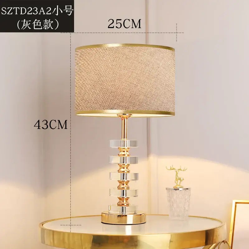 Modern gold and white crystal table lamp with textured beige fabric shade and stacked crystal tiers for bedroom decorbites crystal table lamp