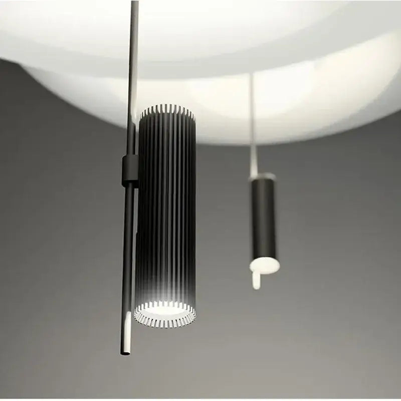Black cylindrical pendant light with vertical ridges and glowing white base for decorbites designer saucer ufo decor
