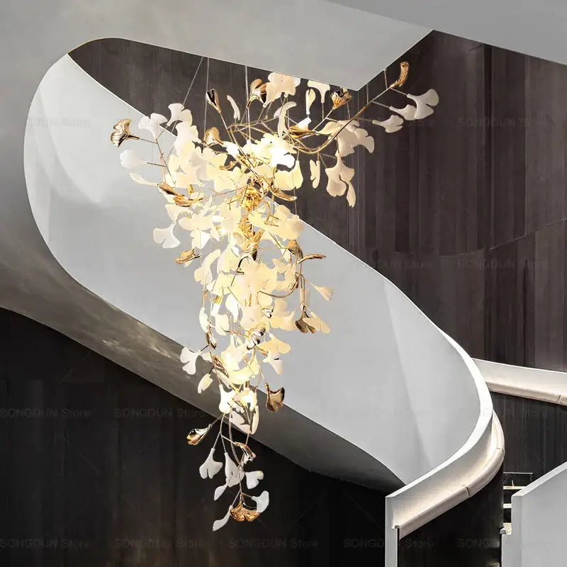 Elegant modern gold and white gingko leaf ceramic chandelier by decorbites hanging above a staircase