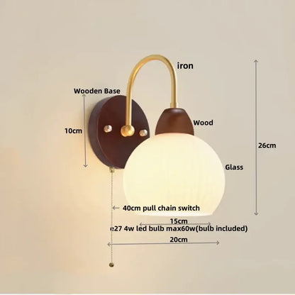Modern gold and white glass wall lamp with warm-toned glass globe, brass iron arm, and dark wood base decorbites iron white