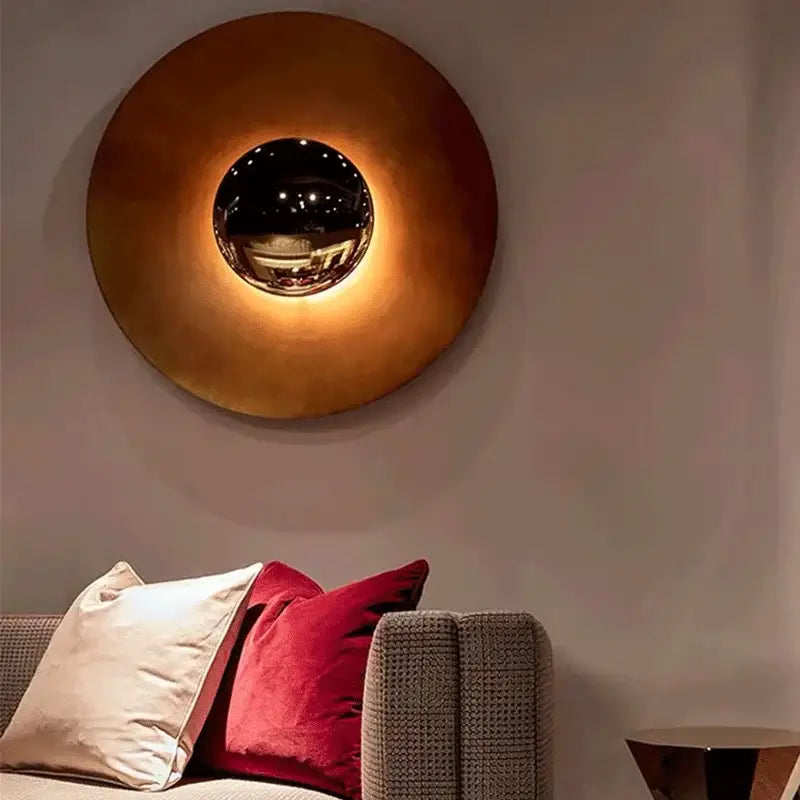 A modern gold and white led ufo wall sconce with warm brass finish and central chrome sphere for bedroom ambiance wall sconces