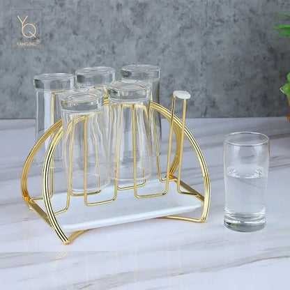 Modern gold and white marble mug holder stand with six clear drinking glasses for kitchen organization