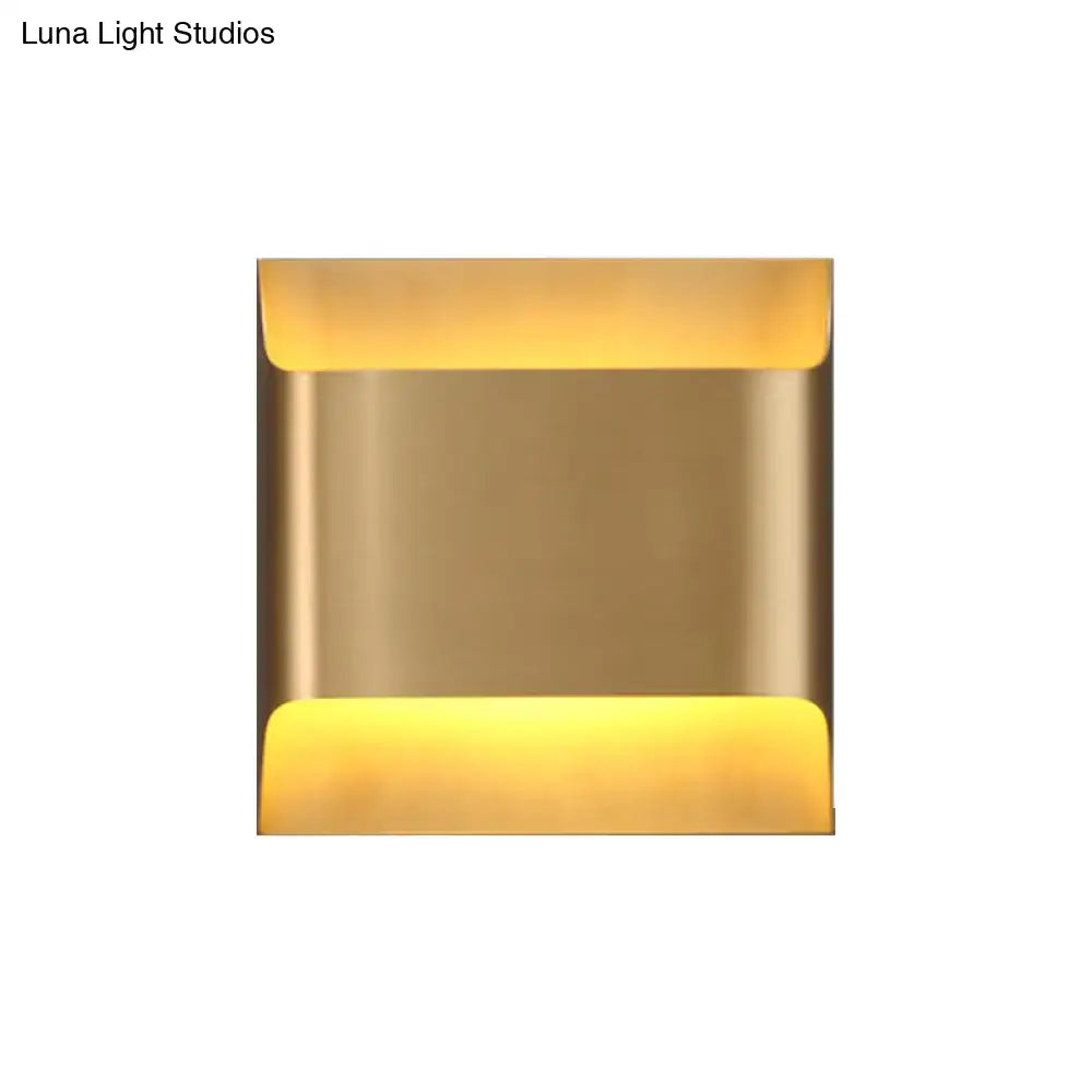 Modern gold angular led living room wall sconce with brass finish and warm yellow light from top and bottom edges