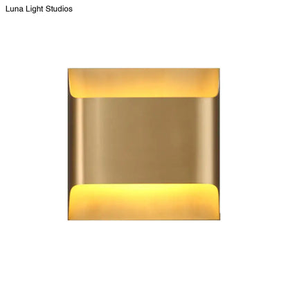 Modern gold angular led living room wall sconce with brass finish and warm yellow light from top and bottom edges