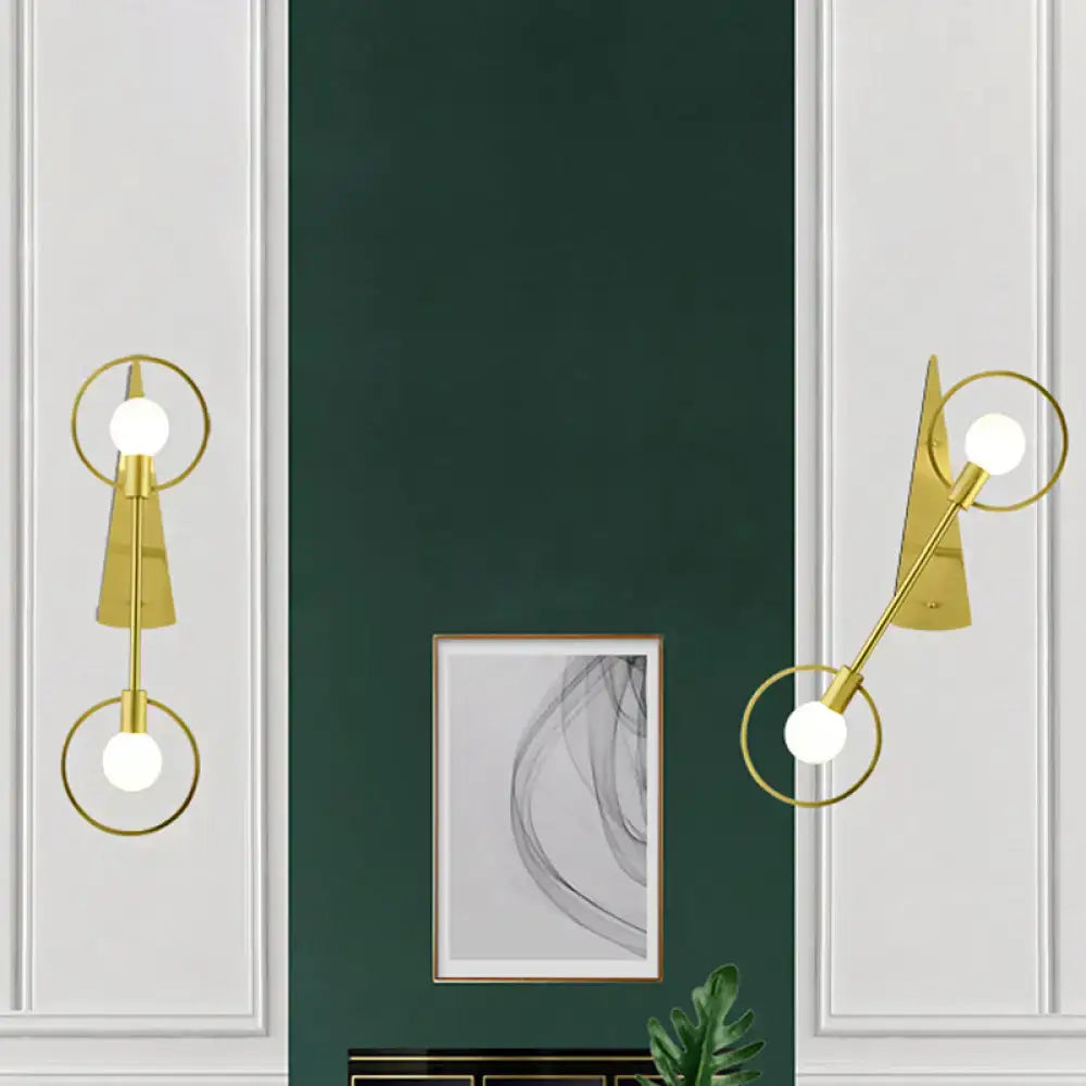 Modern gold angular ring sconce light fixture with circular accents and spherical bulbs for bedroom lighting