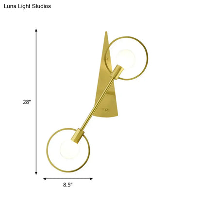 Modern gold angular ring sconce light fixture with two illuminated circular rings and a sleek angular backplate for bedroom
