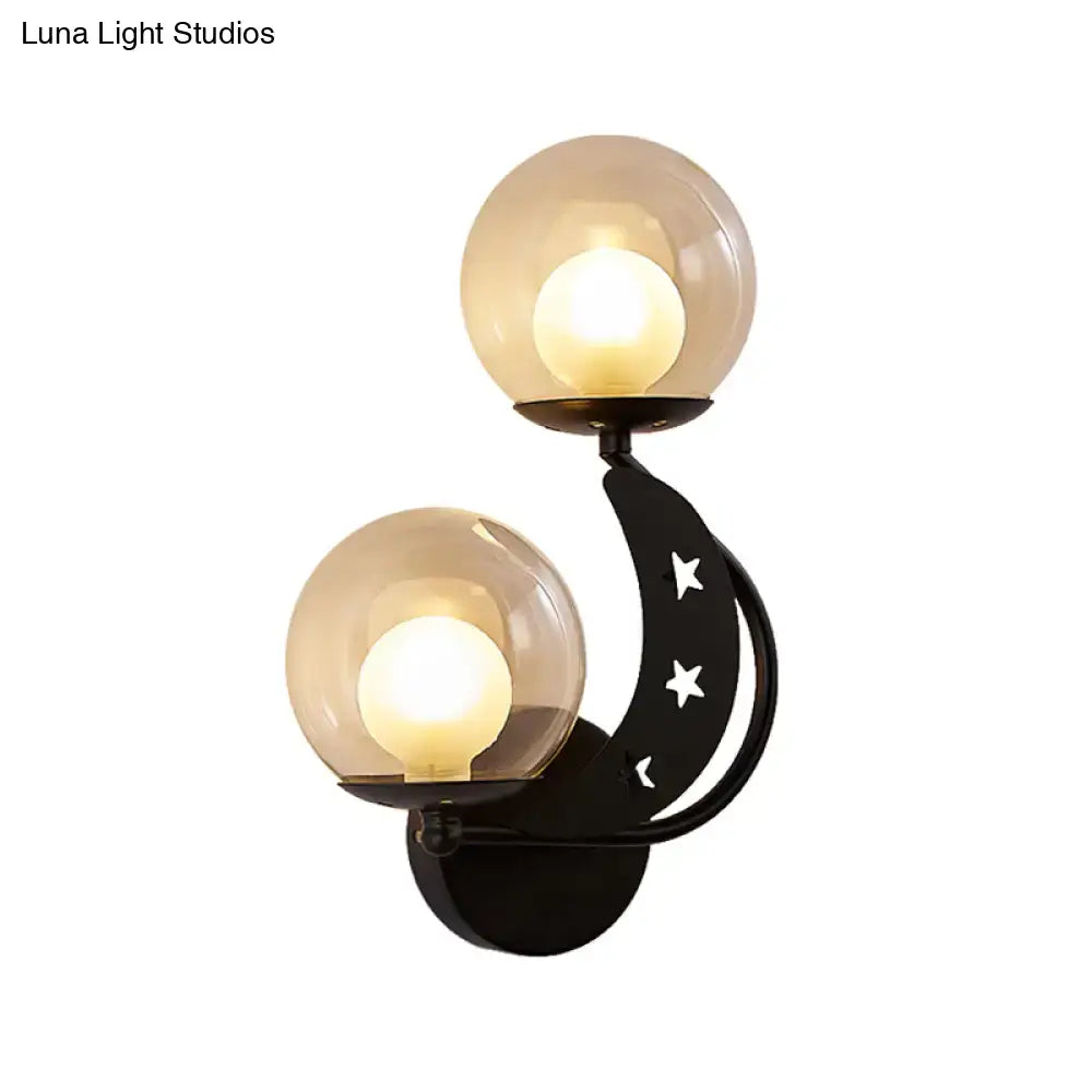 Modern gold and black ball wall sconce with black crescent moon shape, star cut-outs, and two frosted glass globe shades