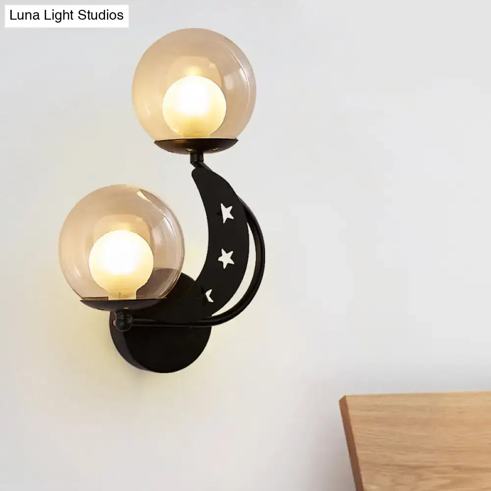 Modern gold and black ball wall sconce with crescent moon design and amber glass shades for bedroom lighting