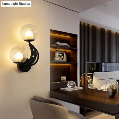 Modern gold and black ball wall sconce with two spherical glass shades and crescent moon design for bedroom lighting