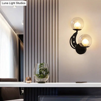 Modern gold and black ball wall sconce with two glass globes and crescent moon design for bedroom lighting