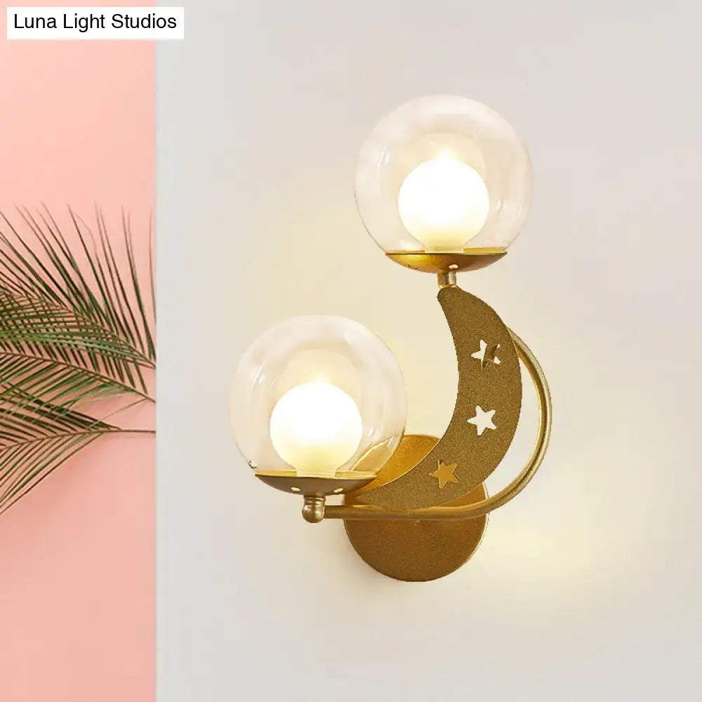 Modern gold and black ball wall sconce featuring gold-toned crescent moon with star cut-outs and two clear glass globes