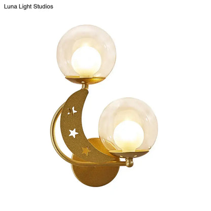 Modern gold and black ball wall sconce featuring crescent moon cut-out stars and two frosted glass globes for bedroom lighting