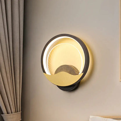 Modern gold and black circular led wall sconce with black outer ring gold accents and illuminated fan design for bedroom lighting