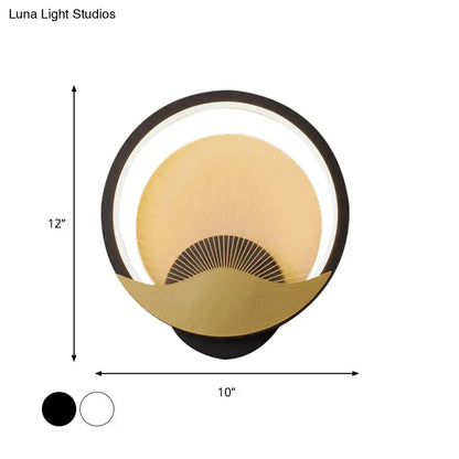 Modern gold and black circular led wall sconce with a black outer ring, gold inner fan design, and illuminated halo
