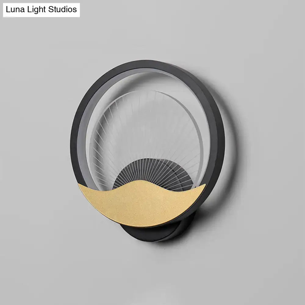 Modern gold and black circular led wall sconce with black frame clear glass diffuser and gold crescent accent for bedroom lighting