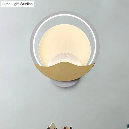 Modern gold and black circular led wall sconce with gold-toned crescent base and frosted glass diffuser for bedroom use