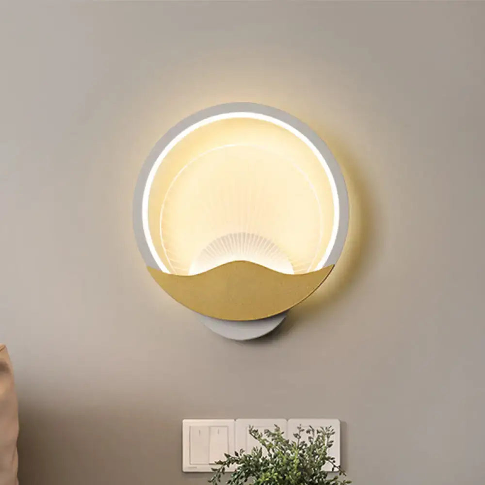 Modern gold and black circular LED wall sconce with white outer ring and gold crescent moon shape for bedroom lighting