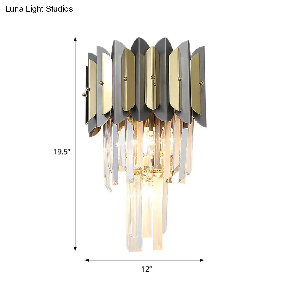 Modern gold and black crystal sconce light fixture with metallic leaf plates and cascading crystal prisms for bedroom walls