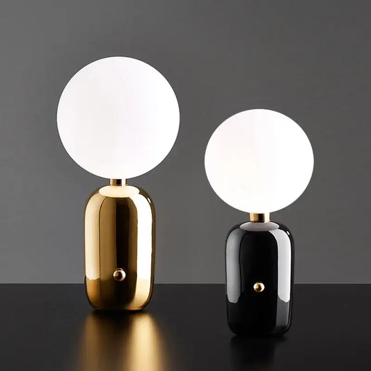 Two modern decorbites glass ball desk lamps with gold and black bases featuring white spherical glass ball led shades