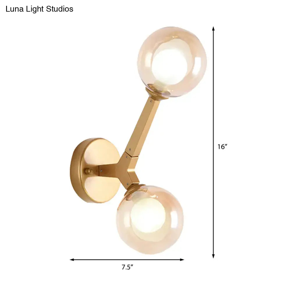Modern gold and black double globe wall lamp with gold-toned frame and two spherical amber glass shades for corridor lighting