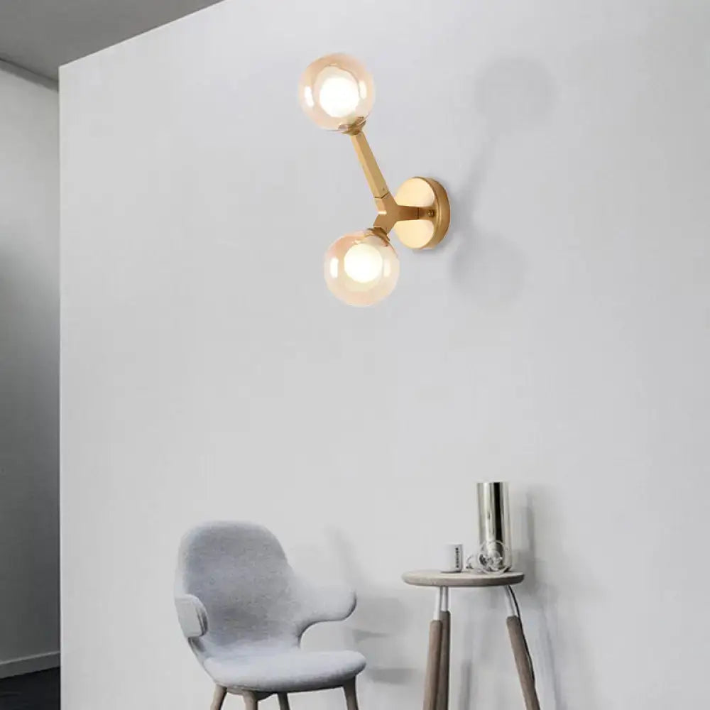 Gold-toned modern wall lamp with double globe glass bulbs designed as a corridor sconce light fixture