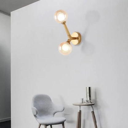 Gold-toned modern wall lamp with double globe glass bulbs designed as a corridor sconce light fixture