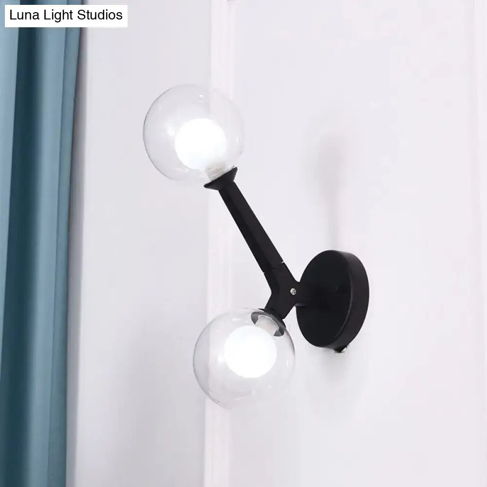 Black wall lamp with two clear glass globe shades featuring modern gold and black double globe wall design