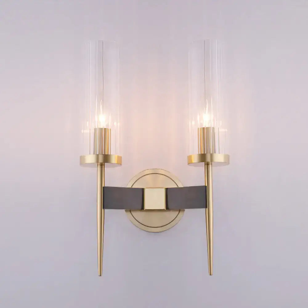 Modern gold wall lamp with black fluted glass cylinders and central dark gray leather strap for bedroom sconce lighting