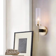 Gold-toned wall lamp with clear fluted glass shade and black accent bar for modern bedroom sconce lighting