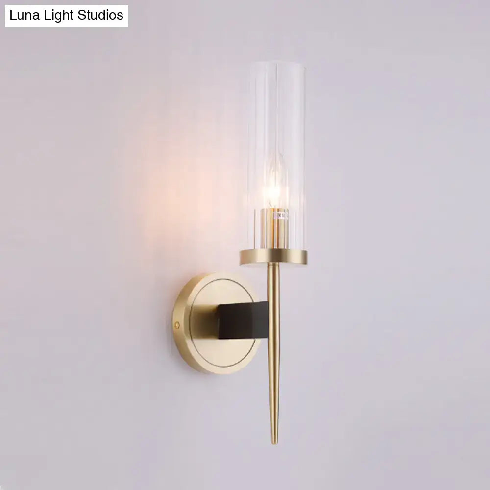 Modern gold and black wall lamp with fluted clear glass shade and black accent bar for bedroom sconce lighting