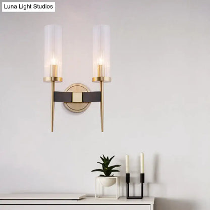 Modern two-light wall lamp with gold metal arms, fluted frosted glass shades, and black leather strap accent