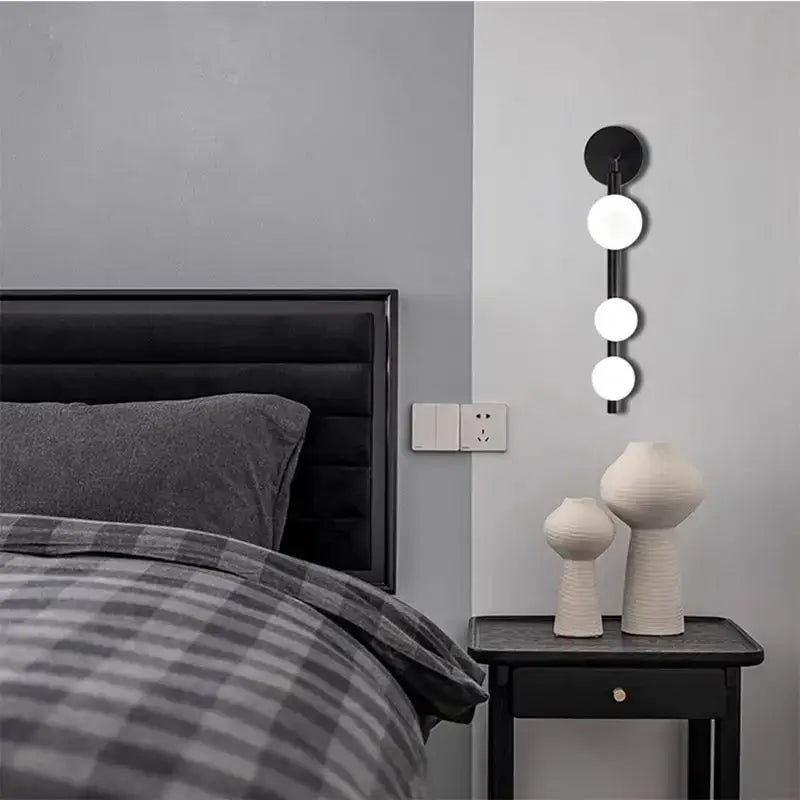 Black wall-mounted glass ball wall lights with three vertically aligned bulbs for modern decorbites living room decor