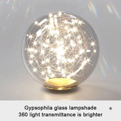Modern pendant light with clear glass globe, golden wireframe, embedded fairy lights, gold base, and selectable light colors