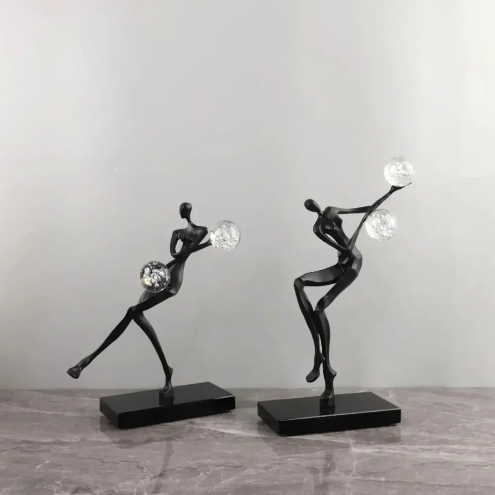 Modern gold and black golden man crystal ball sculpture with sleek black abstract figurines and clear crystal spheres decorbites golden man