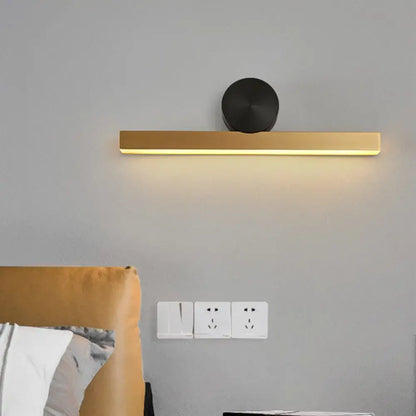 Modern gold and black wall sconce with sleek rectangular design and black circular accent for living room fixture width
